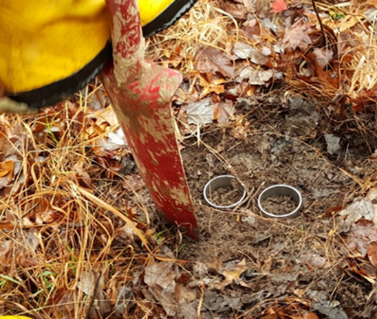 Two open-ended steel cylinders inserted into the soil.